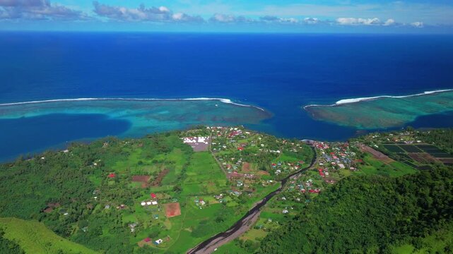 Aerial drone view village of town Teahupo'o surf wave lagoon End of the Road Tahiti French Polynesia sunny morning blue sky neighborhood lagoon surfing Passe Havea coral reef Vaiau River circle left