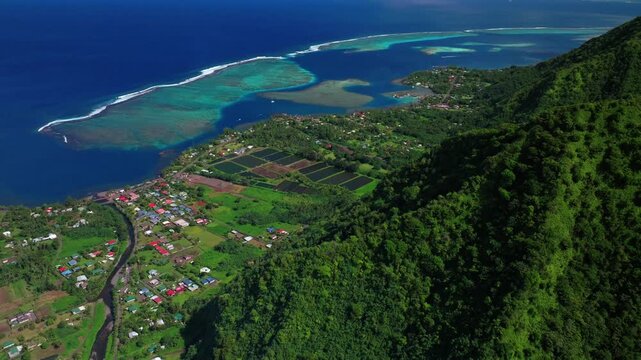 Teahupo'o surf wave lagoon farming land Tahiti French Polynesia aerial drone view village of town sunny morning blue sky neighborhood lagoon surfing Passe Havea coral reef Vaiau River forward pan