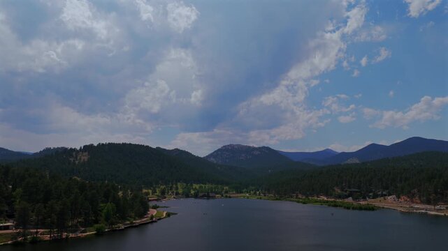 Aerial drone view of Evergreen Lake Evergreen Colorado foothills Denver Golf Course Upper Bear Creek Mt Blue sky Front Range Rocky Mountain summer spring sunny cloudy morning paddleboarding pan left