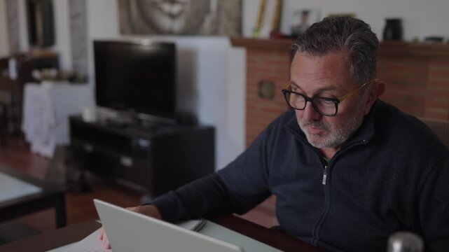 Senior businessman working from home on laptop