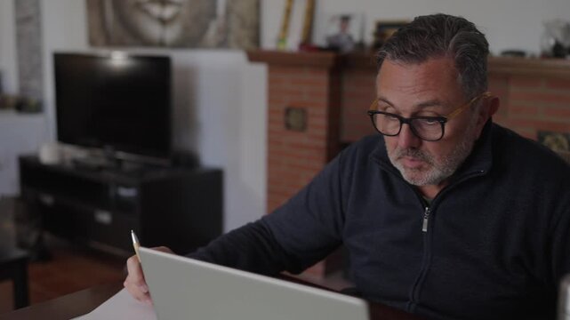 Mature businessman working from home on laptop