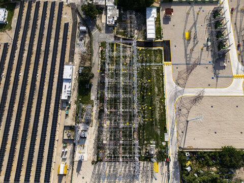 Aerial view of a solar power plant featuring rows of photovoltaic panels and electrical substation infrastructure in Merida, Yucatan, Mexico.