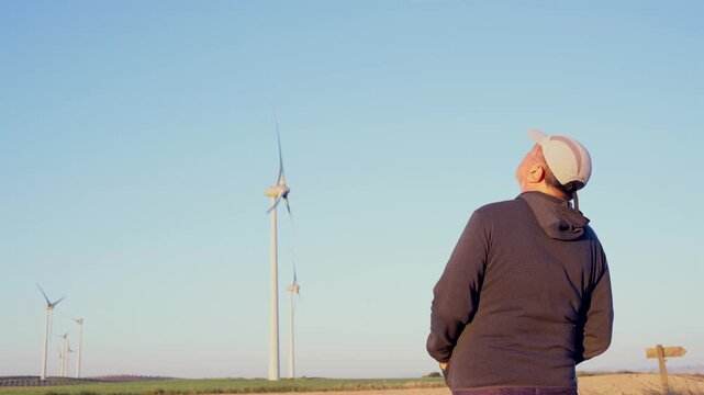Man watching wind turbines generating renewable energy