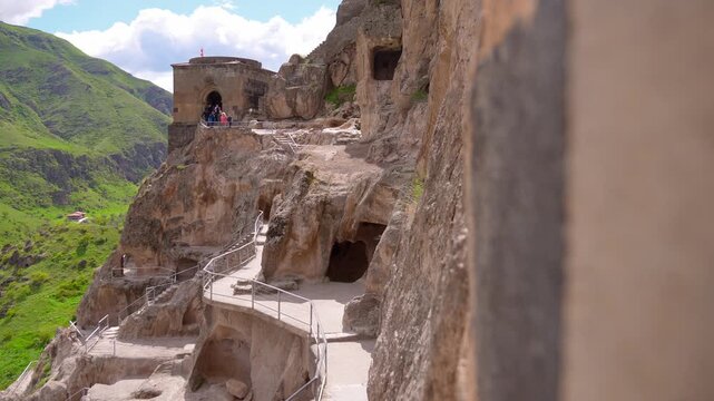 Revealing view of the ancient vardzia cave city monastery, a cultural heritage site carved into the erusheti mountain, with tourists exploring the historical landmark on a sunny day