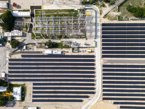 Aerial view of the solar power plant with rows of photovoltaic panels and an electrical substation in the city, Merida, Yucatan, Mexico.