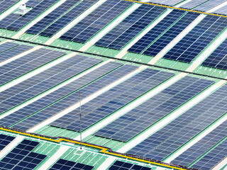 Solar energy system installed on the rooftop of an industrial factory and warehouse. Clean and renewable power solutions, green energy innovation, and sustainable commercial electricity generation. © Fahroni
