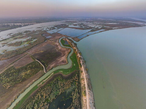 Aerial view of Qadirabad Head Works Bridge spanning the Chenab River with surrounding wetlands, agricultural fields, and irrigation channels in Wazirabad, Punjab, Pakistan.