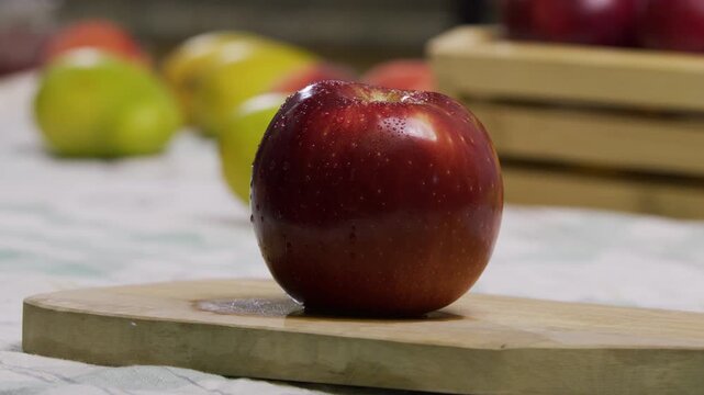 Sharp knife cutting up fresh red apple on cutting board - closeup slow motion shot