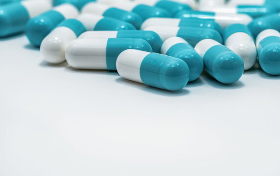 Blue and white antibiotic capsule pills on white background. Antimicrobial resistance, pharmaceutical industry, prescription medication, healthcare, pharmacy supplies and modern medical treatment.
