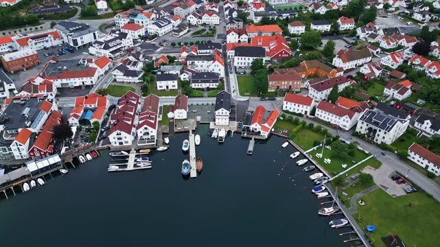 Aerial view of the picturesque coastal town of Lillesand with its characteristic white wooden houses, harbor, and moored boats in Lillesand, Agder, Norway.