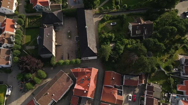Aerial view of the charming town of Mandal featuring traditional white houses with red roofs and narrow streets in Mandal, Agder, Norway.