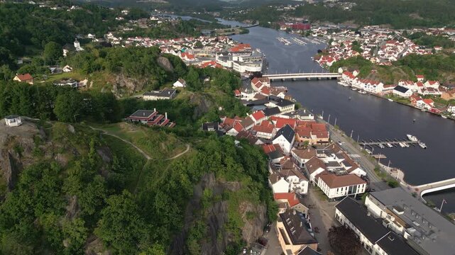 Aerial view of Mandal town with its river, bridge, and surrounding green hills in Mandal, Agder, Norway.