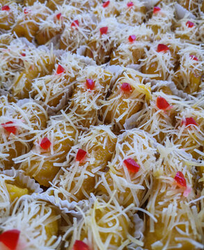 Close up of Indonesian pisang keju, fried banana topped with shredded cheese and sweet garnish. Popular street food dessert with rich texture and vibrant colors.