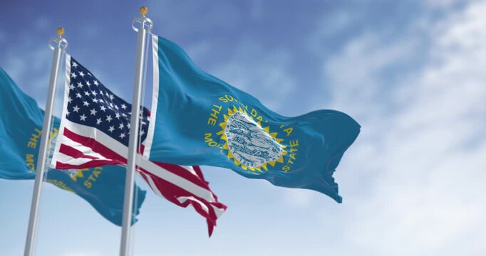 The South Dakota state flag waving along with the national flag of the United States of America