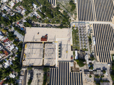 Aerial view of a solar farm with rows of photovoltaic panels and an electrical substation located in the city of Merida, Yucatan, Mexico.