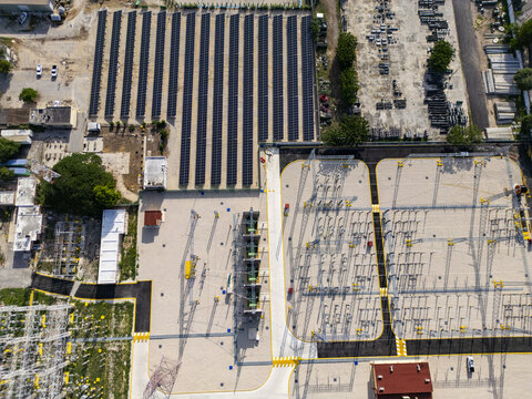 Aerial view of a solar panel array and electrical substation with rows of photovoltaic panels and power infrastructure in Merida, Yucatan, Mexico.