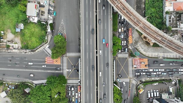 Aerial view of the busy highway intersection in Fatmawati with elevated railway tracks, flowing traffic, and urban surroundings in Cilandak, Jakarta, Indonesia.