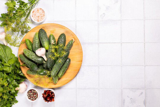 Fresh cucumbers and pickling ingredients on white background