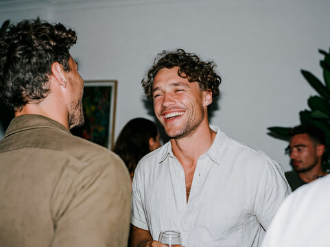 Three Happy Friends Laughing Together at Outdoor Night Event or Party