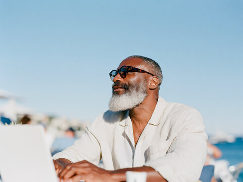 Confident Senior Man with Gray Beard Looking Up Outdoors in Bright Daylight
