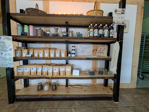 Quebec, Canada, 16 May 2026 : Display shelves showcase various artisanal products including MONIN syrups, herbal teas, and bakery accessories in a store.