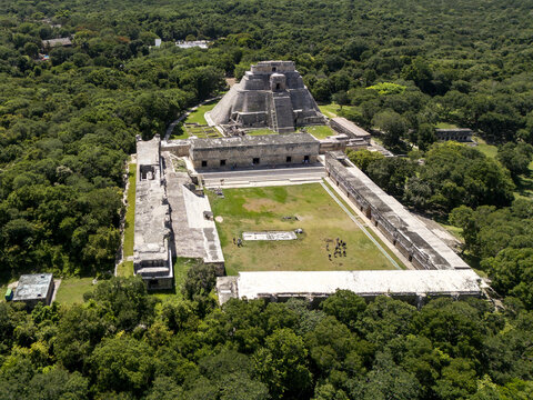 Aerial view of the Pyramid of the Magician and the Nunnery Quadrangle at the ancient Mayan city of Uxmal surrounded by dense jungle in Uxmal, Yucatan, Mexico.