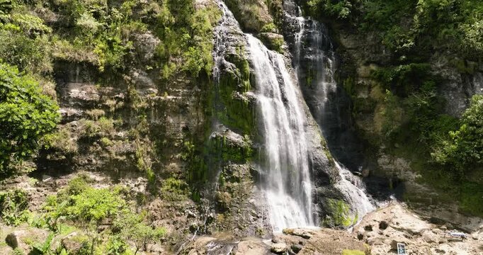 Waterfall among tropical jungle with green plants. Balea Falls in the jungle. Negros, Philippines.