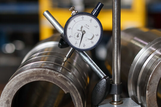 Dial indicator measuring car transmission shaft runout.