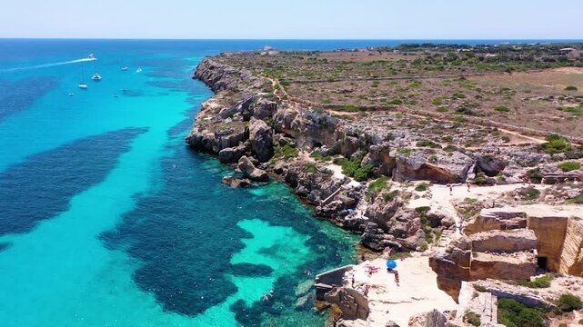 Favignana island coastline, Italy, with boats enjoying the turquoise water. Sicily, Italy