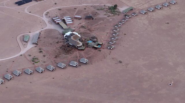 Aerial view of a desert lodge surrounded by vast arid plains near the Namib-Naukluft National Park in Namibia.