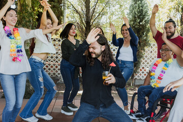 Naklejka premium large group of latin friends dancing in a party in terrace outdoors in Mexico Latin America. Diverse Hispanic people men and women multi age having fun