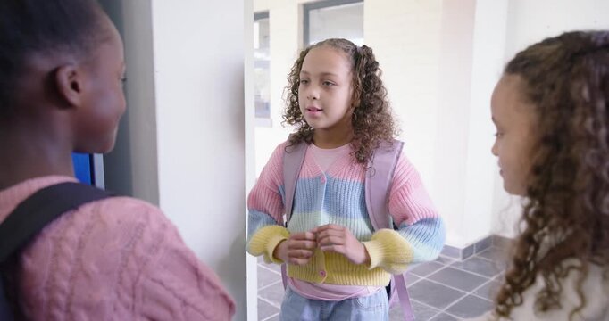 African American peers listening as girl in pastel knit apologizing, peers walking past backpacks
