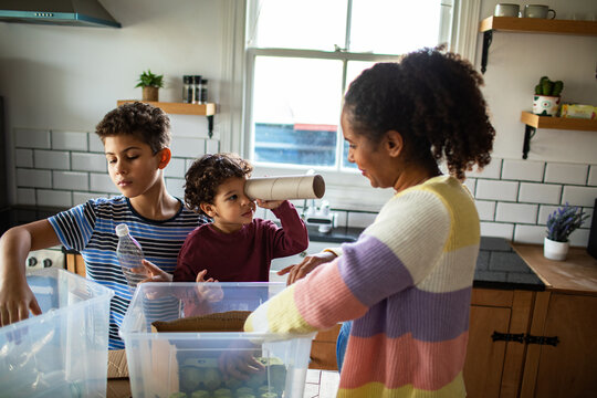 Mother and children sorting recycling in kitchen