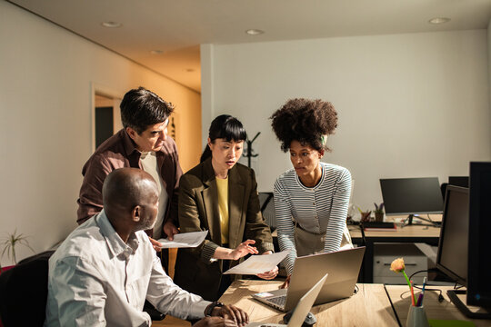 Coworkers collaborating on project in modern office