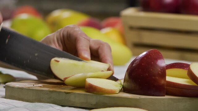 Cook slicing up red apple - closeup, slow motion