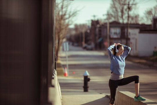 Woman stretching before run on urban street