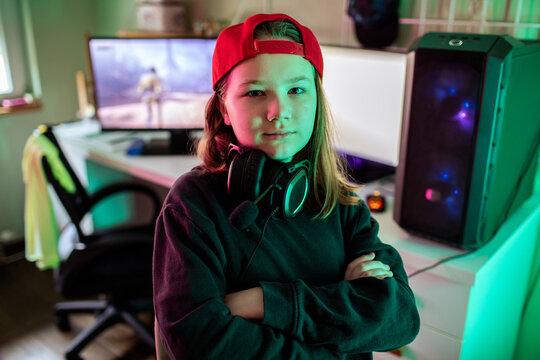 Confident young gamer with headset at home gaming setup