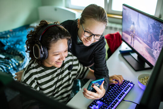 Two friends playing pc games at home