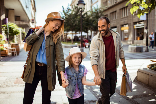 Happy family shopping together on city street