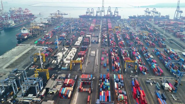Jakarta, Indonesia - 18 July 2026: Aerial view of Port of Tanjung Priok with rows of colorful shipping containers and industrial cranes.