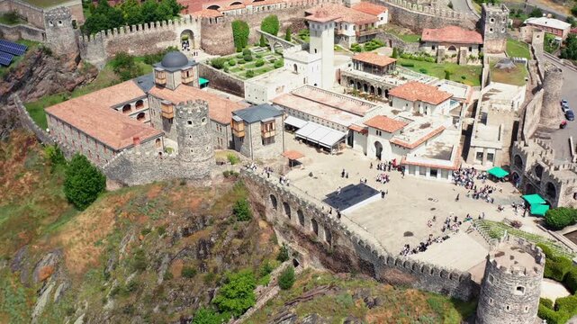 Akhaltsikhe Fortress recedes in elevated aerial view above central courtyards, towers and tiled roofs, supporting heritage documentaries, cultural tourism and regional destination marketing in Georgia