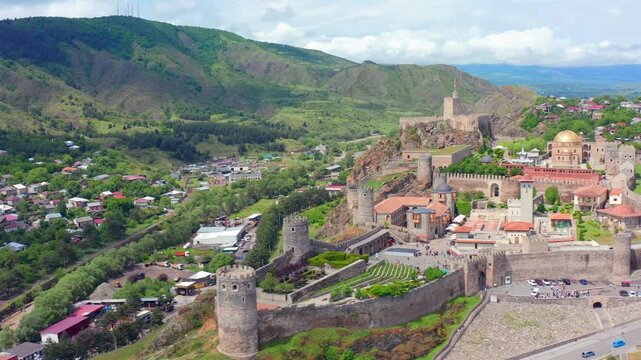 Aerial drone orbits Rabati Fortress in Akhaltsikhe, Georgia, revealing fortified walls, mosque dome, towers and mountain valley surroundings for cultural tourism, religious history, travel campaigns