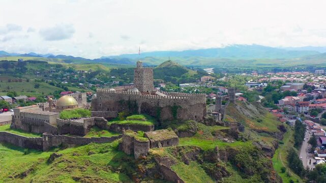 Rabati Fortress recedes in aerial view above stone ramparts, towers and Akhaltsikhe city, supporting Georgian heritage tourism, urban geography, history programs and destination marketing campaigns.