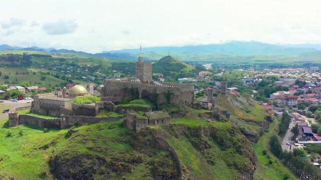 Rabati Fortress approaches in aerial view across fortified walls, mosque dome and Akhaltsikhe neighborhoods, supporting castle tourism, Georgian history, architecture media, regional travel promotion.