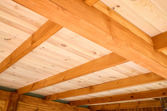 Interior view showcases rustic wooden ceiling crafted from natural Douglas fir timber planks with parallel exposed beams creating warm geometric architectural pattern inside cottage log home.