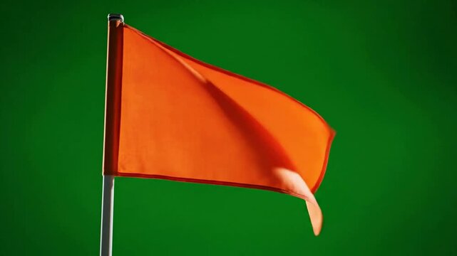 Bright orange flag waving in the wind isolated on green screen background, for easy compositing, and chroma key editing