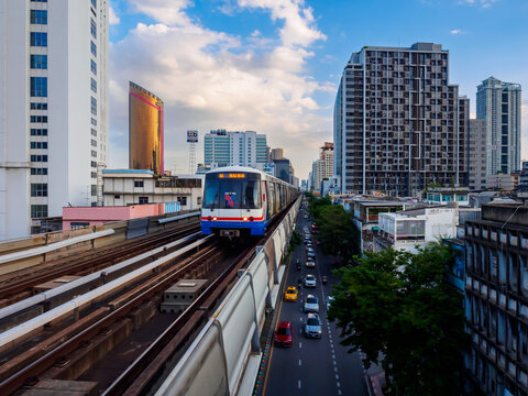 Bangkok, Thailand - July 8, 2026 : The BTS Skytrain runs in and out of Saphan Kwai Station in the afternoon, also offering views of Bangkok's beautiful office buildings.