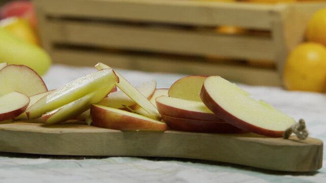Thinly sliced apples on wooden cutting board - closeup, panning shot