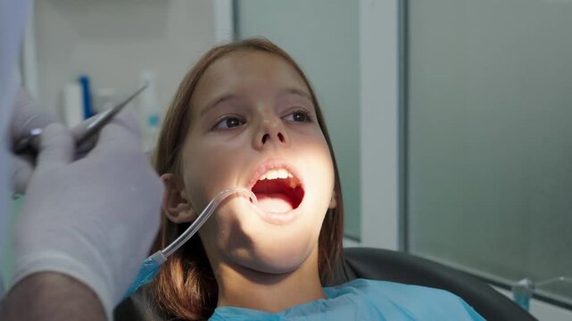 Pediatric dentist examining teeth with mirror and probe for young girl