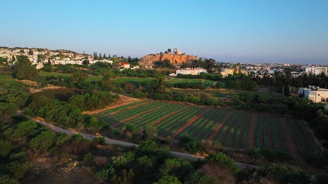 Aerial view of Profitis Elias Church in Protaras, Cyprus. The hilltop church rises above green fields, farmland and the surrounding coastal landscape.